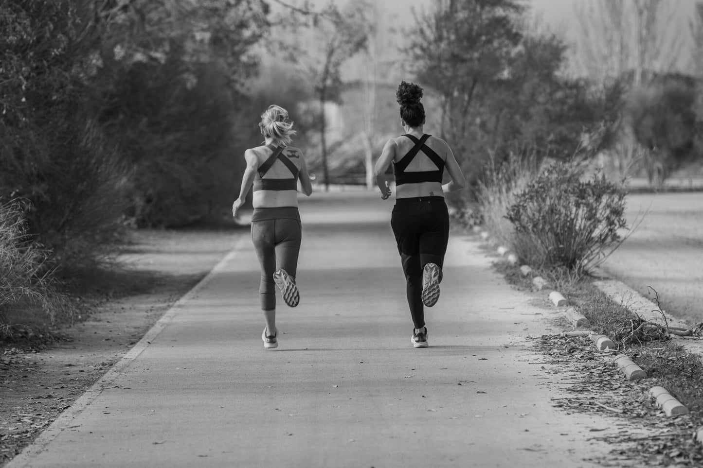 Two women running to improve fitness and wellness, supported by supplements from Centenarian Road to enhance performance and overall health.