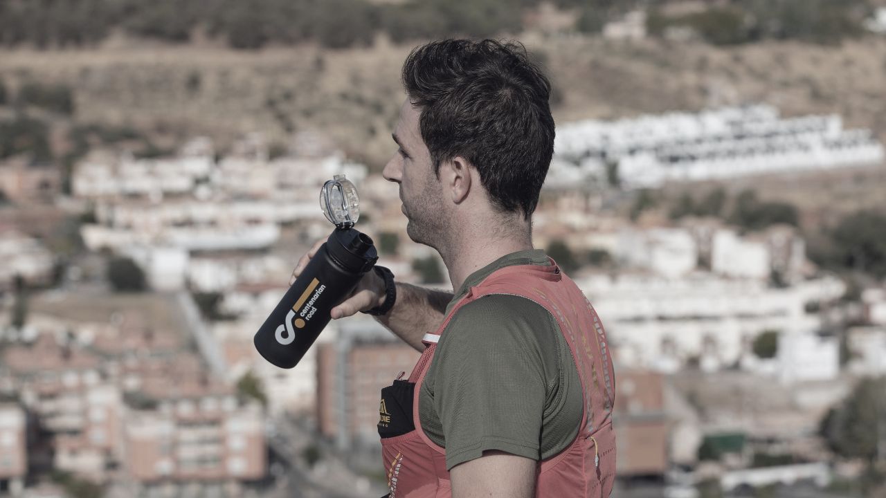 hombre con botella de centenarian road con ciudad de fondo