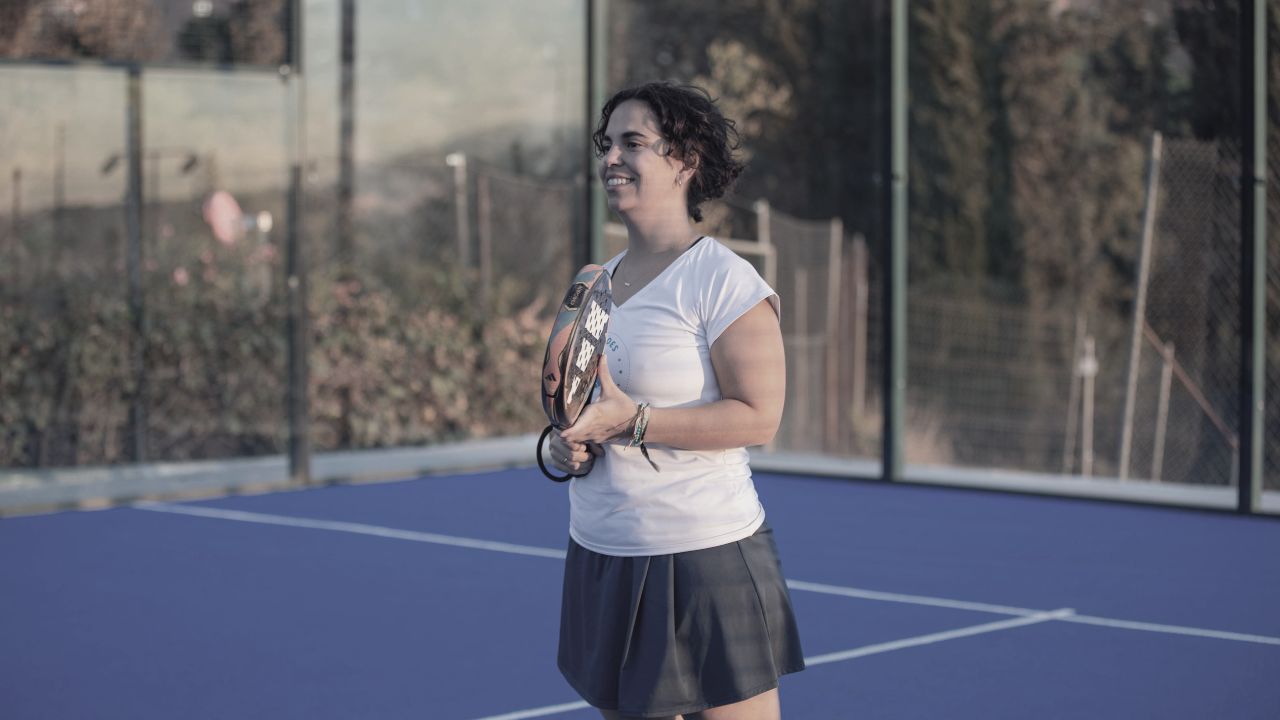 Mujer en pista de tenis con raqueta de tenis