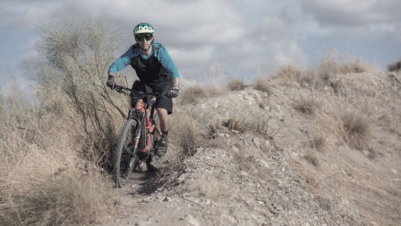 Hombre con bicicleta en mitad de la montaña