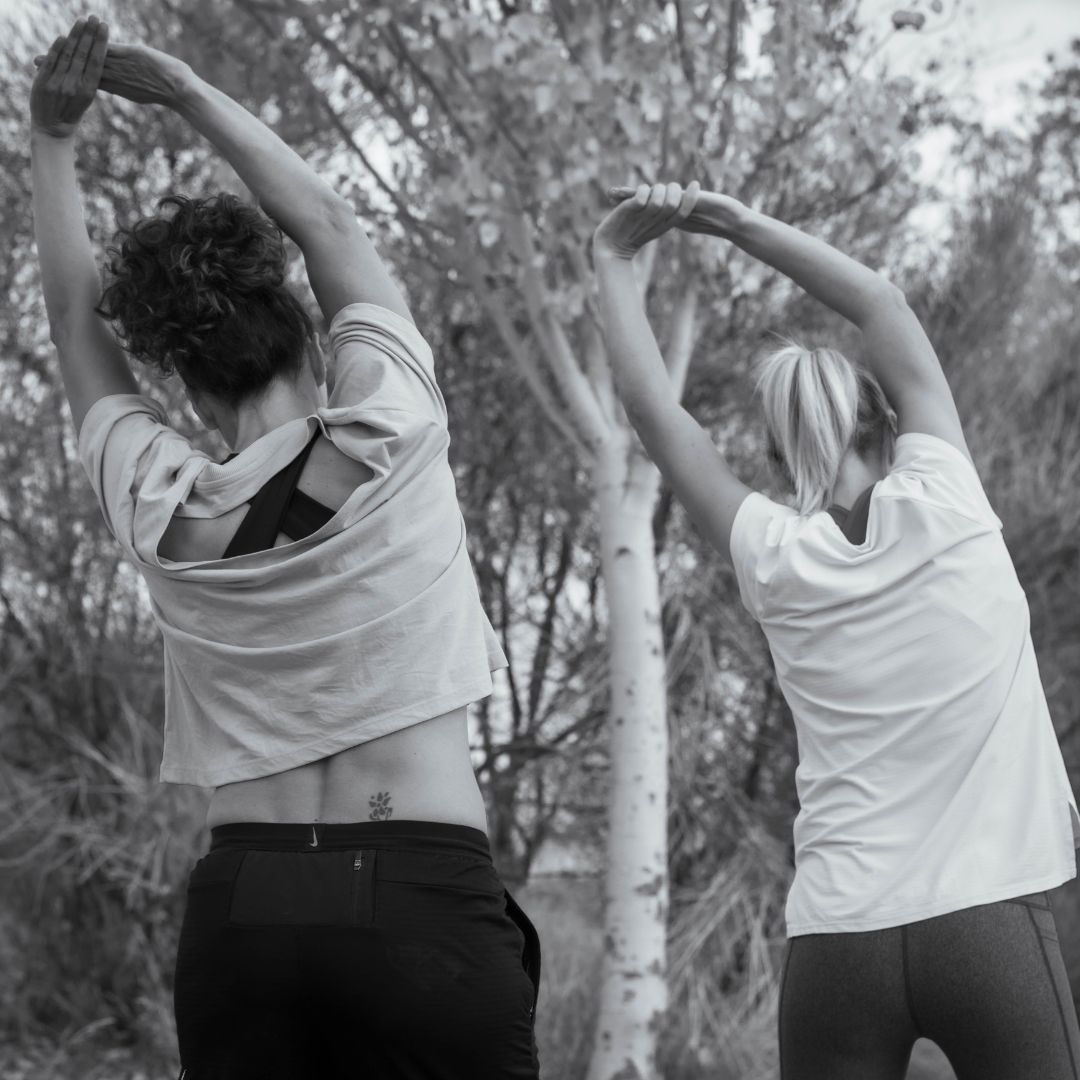 Two women stretching during a routine focused on mobility, flexibility and physical wellbeing